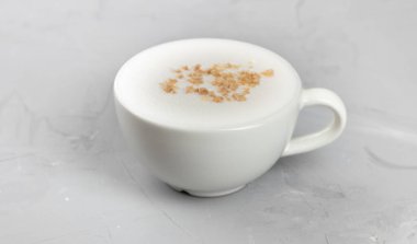 Beton arka planda fındıklı beyaz kahve.