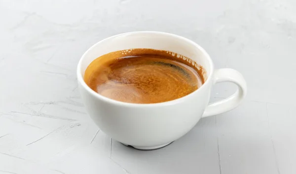 コンクリートの背景に熱いコーヒーアメリカの白いカップ — ストック写真