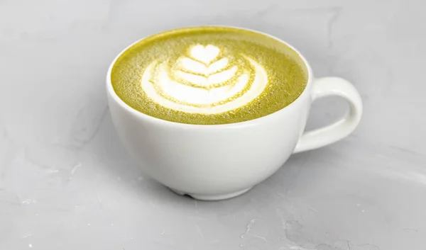 コンクリートの背景に熱い抹茶コーヒーの白いカップ — ストック写真