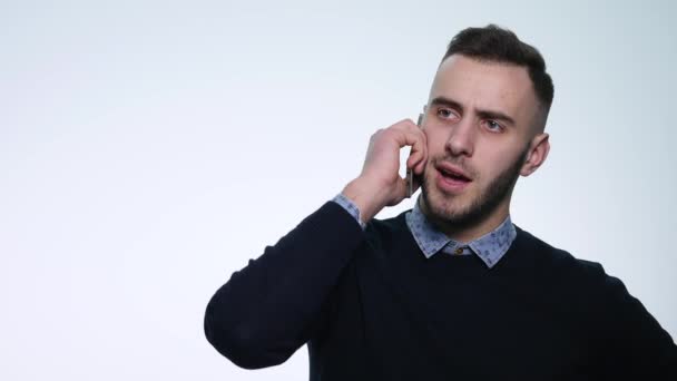 Cep telefonunu konuşan genç gülen adam. beyaz izole. Genç adam konuşmak için cep telefonu — Stok video