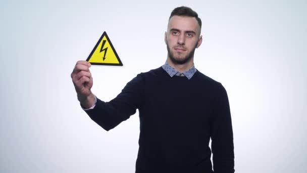 Young man holding signs under voltage on a white background — Stock Video