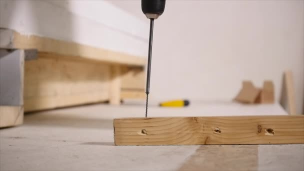 Werknemer corrigeert het bord aan de muur met behulp van elektrische schroevendraaier — Stockvideo