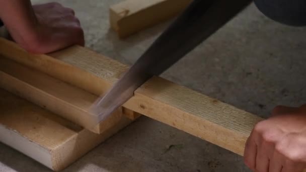 Работник распиливает деревянную ручную пилу — стоковое видео