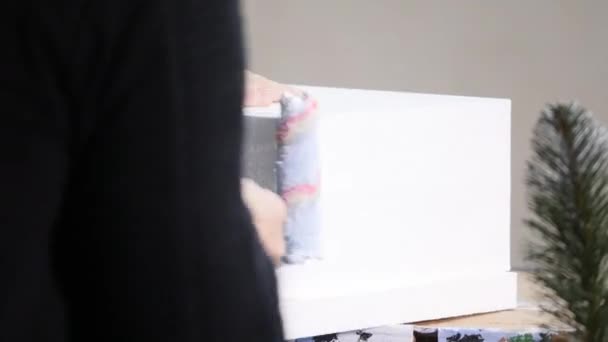 Hand van een arbeider in close-up. een korte verwerkte foam roller aangrijpend en schilderwerken van een muur met een verse laag. — Stockvideo