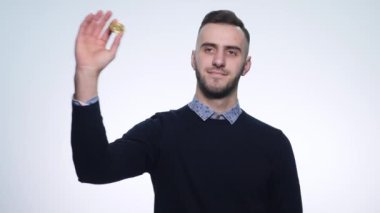 Bir madeni para bitcoin olan genç bir adam