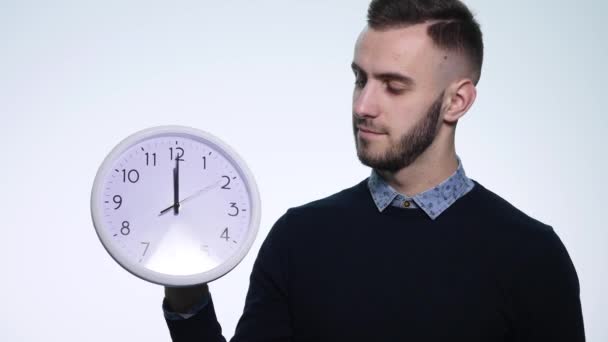 Человек держит часы на изолированном белом фоне — стоковое видео
