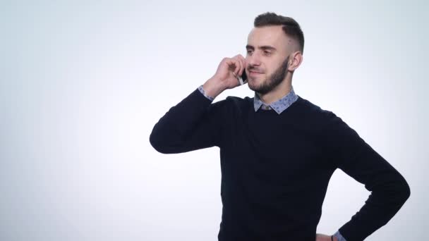 Un giovane uomo sorridente che parla al cellulare. isolato su bianco. Giovane parlare con il telefono cellulare — Video Stock