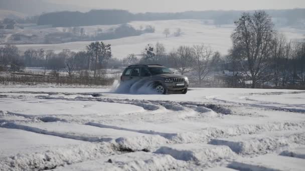 DRIVING IN THE SNOW. Winter car tracks on snowy beach. Driving a race car on a snowy road. Track Winter car racing with sun reflection. Race on the track in the winter — Stock Video
