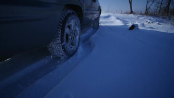 SUV με χιονισμένο ζάντες και τα ελαστικά χειμώνα οδήγηση στο χιόνι, προβολή με μεγέθυνση — Αρχείο Βίντεο