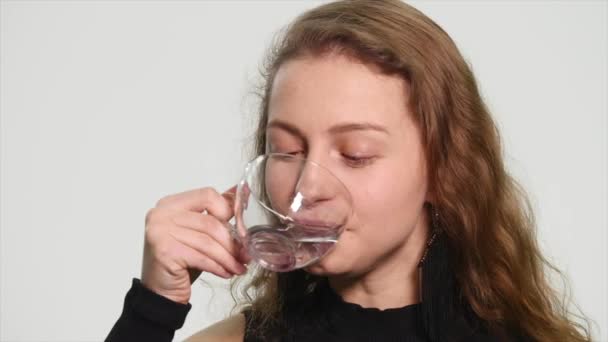 Jovem mulher bonita água potável, fundo branco — Vídeo de Stock