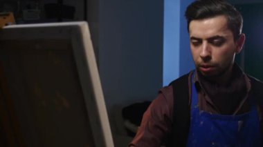 Sanatçı-ressam boyalar stüdyoda bir resmi. O genç ve çekici..