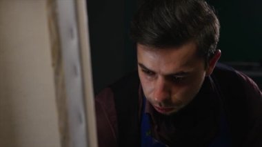 Sanatçı-ressam boyalar stüdyoda bir resmi. O genç ve çekici.