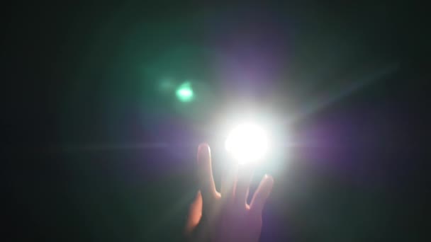Mörka silhuetten av mänskliga manliga handen med upphöjda fingrar i spotlight eller bakgrundsbelysning ljus med gest på svart bakgrund med dramatiska projektorn glans ray eller balk — Stockvideo