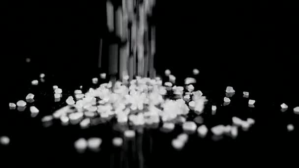 Coarse sea salt crystal falling on black background — Stock Video