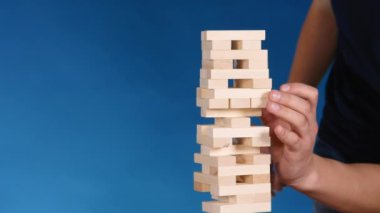 Eller boardgame Jenga oynamayı mans. mavi arka plan