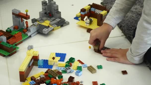 Een jong kind speelt in de constructor. Spel van de childrens ontwerper. Gekleurde blokjes. Handvuurwapens zijn aangesloten kubussen met elkaar — Stockvideo