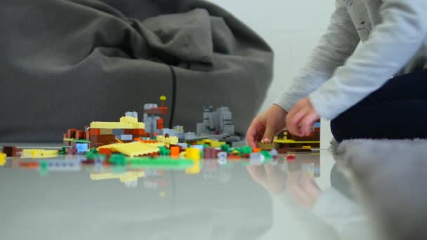 Petits enfants jouant avec beaucoup de blocs en plastique coloré 