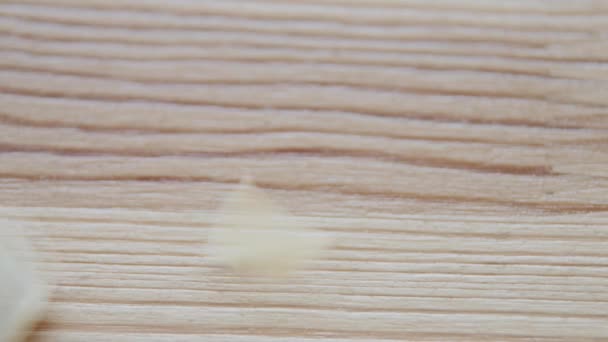 Pompoenpitten vallen op de houten achtergrond — Stockvideo