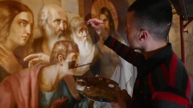 30.01.2018, Chernivtsi, Ukrayna - erkek sanatçı olduğunu ayakta ve simge, Ortodoks bir palet ile boyar Holding Saint, boyama
