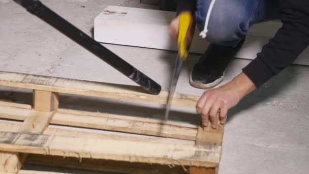 Работник распиливает деревянную ручную пилу — стоковое видео