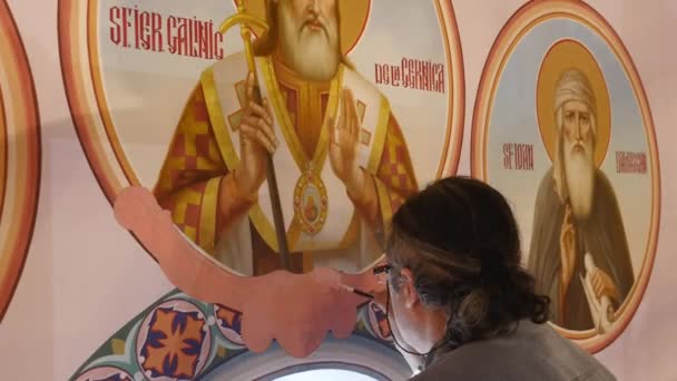 30.01.2018, Chernivtsi, Ucrânia - Artista Masculino está de pé e pintando o Ícone do Santo Ortodoxo, segurando uma paleta com tintas — Vídeo de Stock