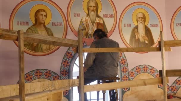 30.01.2018, Tsjernivtsi, Oekraïne - mannelijke artiest is permanent en schilderen de pictogram van orthodoxe heilige, die houden van een palet met verven — Stockvideo