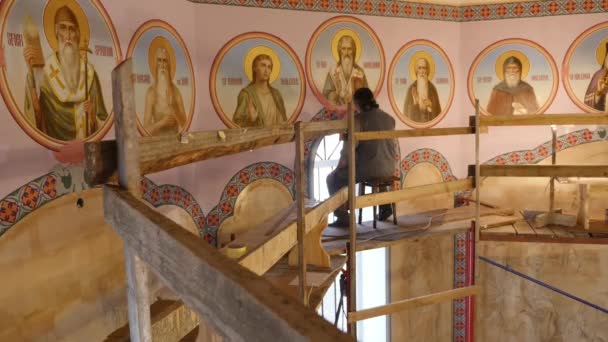 30.01.2018, Tscherniwzi, Ukraine - männlicher Künstler steht und bemalt die Ikone des orthodoxen Heiligen, hält eine Palette mit Farben in der Hand — Stockvideo