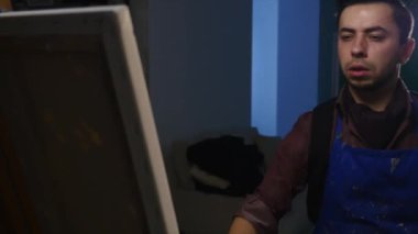 Sanatçı-ressam boyalar stüdyoda bir resmi. O genç ve çekici.