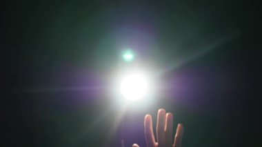 İnsan erkek el jest dramatik projektör Parlatıcı ray veya ışın ile siyah arka plan üzerinde spotlight veya arka ışık ışık koşullarında yükseltilmiş parmak ile karanlık siluet