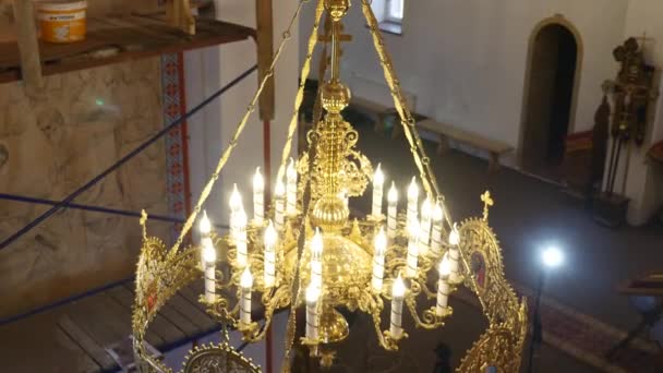 30.01.2018, Chernivtsi, Ucrania - Araña en la Iglesia. Las velas están encendidas en la lámpara de araña en la Iglesia Ortodoxa. en el fondo, una gran iconostasis — Vídeo de stock