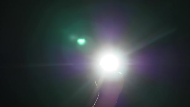 Donkere silhouet van menselijke mannenhand met verhoogde vingers in spotlight of achtergrondverlichting licht met gebaar op zwarte achtergrond met dramatische projector glans straal of bundel — Stockvideo