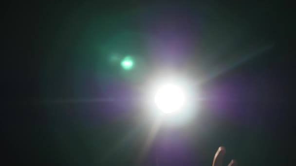 Temná silueta lidské mužské ruky zvednuté prsty ve světle reflektorů nebo podsvícení s gestem na černém pozadí s dramatickým projektor lesk ray nebo paprsek — Stock video