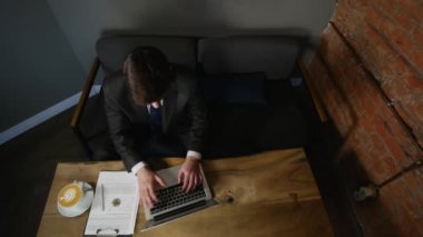 Ahşap masa üzerinde kafede dizüstü kullanarak iş adamı. üstten görünüm