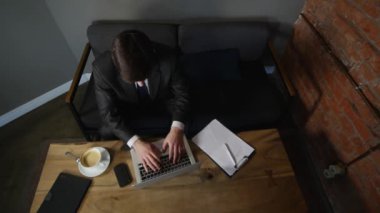 Dizüstü bilgisayarda çalışan ve kafe üzerinde kahve içme iş adamı. işadamı zaferle sevinir. üstten görünüm