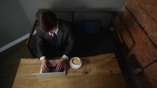 Affärsman arbetar på laptop och dricka kaffe på café. ovanifrån — Stockvideo