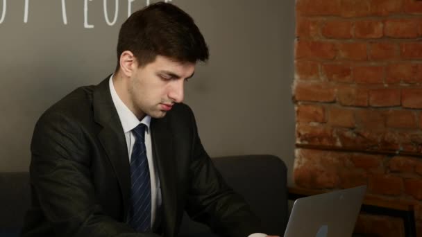 Бізнесмен, використовуючи комп'ютер в кафе — стокове відео
