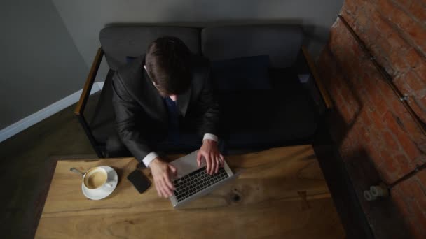 Dizüstü bilgisayarda çalışan ve istemci, kafe aynı masada konuşurken genç iş adamı. üstten görünüm — Stok video