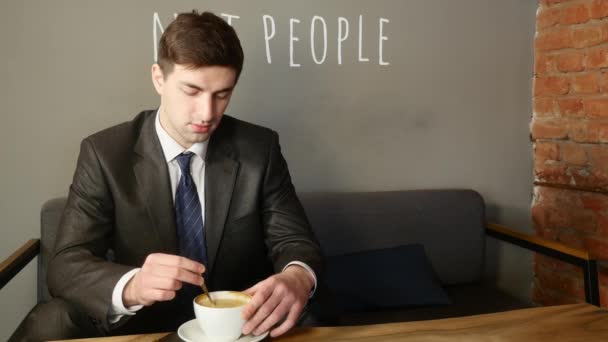 Unge man dricker kaffe på Café — Stockvideo