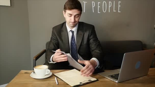 Un uomo d'affari che parla al telefono e distrugge documenti al bar. rallentatore — Video Stock