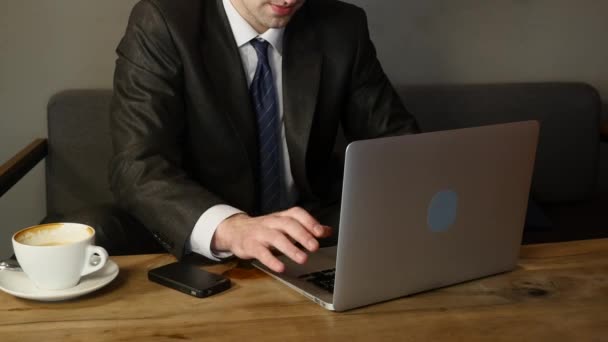 Zakenman werkt aan laptop in café — Stockvideo