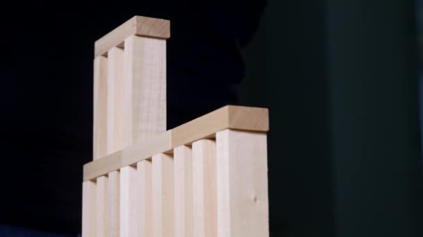 Hands of Young man builds a tower of blocks while playing jenga — Stock Video