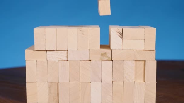 Handen van jonge bouwt een toren van blokken terwijl het spelen van jenga — Stockvideo