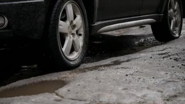 Ağır çekim, Close Up: Bulanık su su birikintisi içine araba sürücüleri olarak asfalt yol boyunca su sıçramalarına. Siyah sokak boyunca kahverengi sıvı spreyler