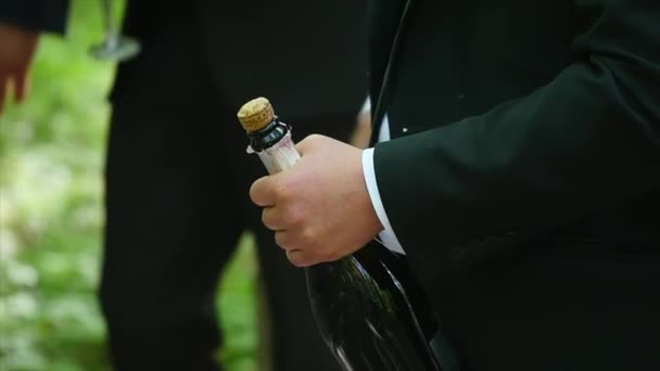 Man opening fles champagne en kurk is vliegt uit — Stockvideo