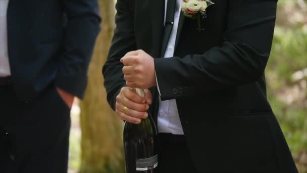 Человек, открывающий бутылку шампанского и пробки вылетает из замедленной съемки — стоковое видео