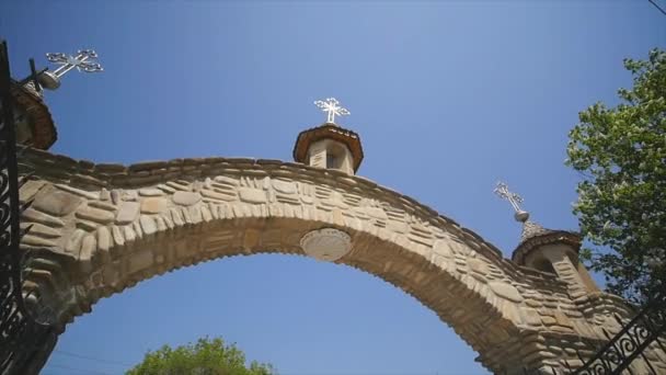 Iglesia ortodoxa, la puerta de entrada al territorio de la iglesia ortodoxa, el arco, día soleado, árboles verdes — Vídeos de Stock