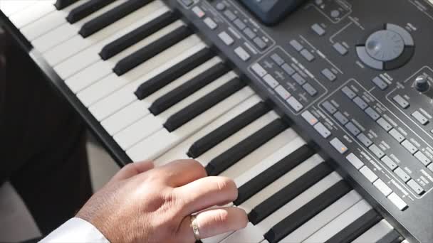Primo piano di una mano di un pianista che suona sulla tastiera. Mani degli uomini sulla tastiera del pianoforte. Mano che suona il pianoforte. Piano di strada . — Video Stock