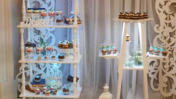Νόστιμα γαμήλια δεξίωση γλύκισμα επιδόρπιο τραπέζι στο εσωτερικό της αίθουσας γιορτή — Αρχείο Βίντεο