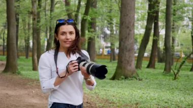 Genç kadın fotoğrafçı işlem açık havada park doğada çekim