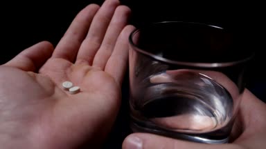 İlacı. Hap ve elinde temiz su. siyah arka plan